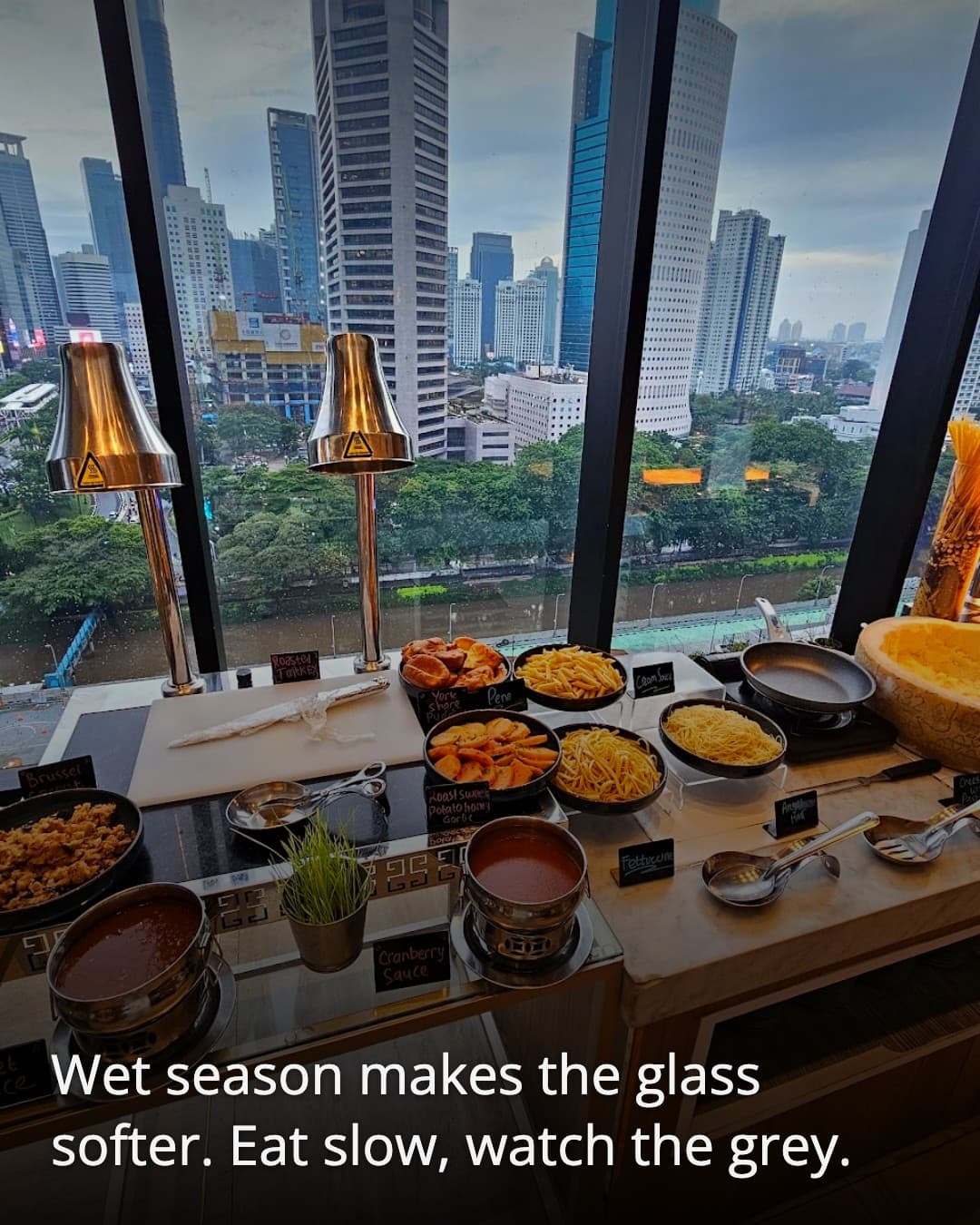 Skyloft Restaurant window view over rainy Jakarta